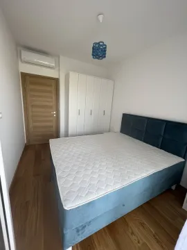 Simple bedroom featuring a blue bed and a white wardrobe. - image 11