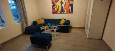 Small living room with a blue sectional sofa, a coffee table, and a painting on the wall. - image 4