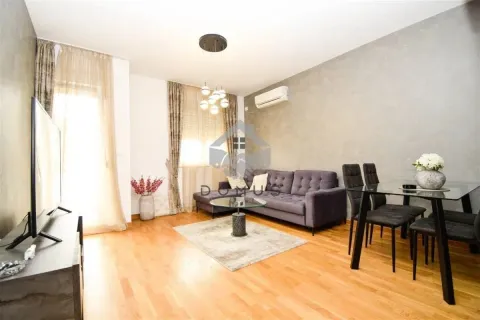 Living room with a sofa, TV, and dining table. - image 2
