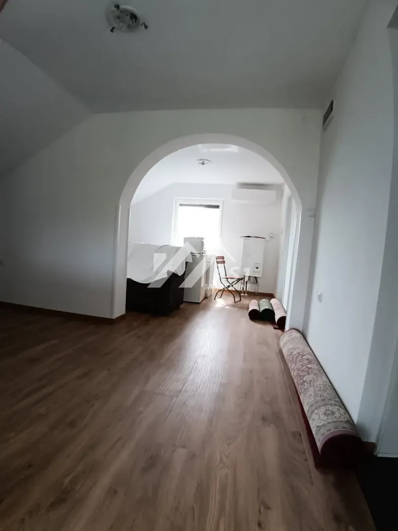 Pogled iz prostorije na dio sa prolazom i spakovanim tepisima.