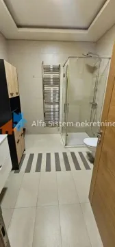Moderno kupatilo sa tuš kabinom, WC šoljom i drvenim ormarićem. - image 9
