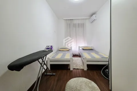 Bedroom with two single beds and an ironing board. - image 9