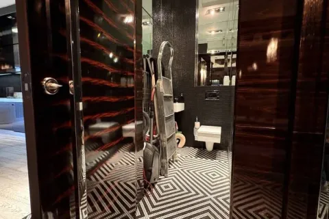 View of a modernly designed bathroom with black and white tiles. - image 15