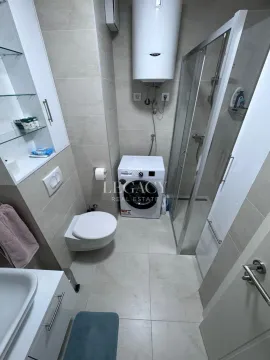 Kupatilo opremljeno tuš kabinom, wc šoljom, umivaonikom i mašinom za veš. - image 7