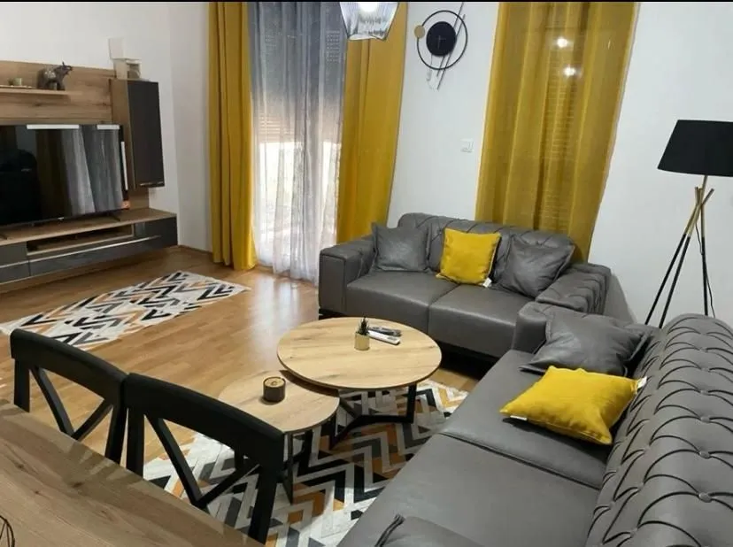 Spacious living room with a sofa set, TV unit, and decorative details.