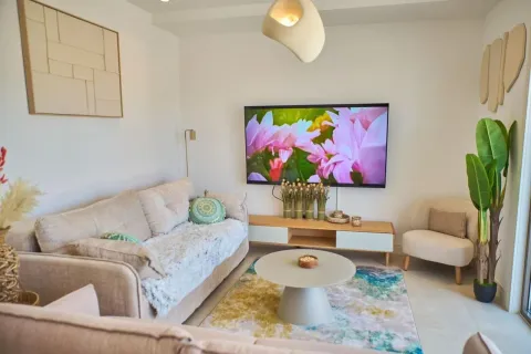 Dnevna soba sa garniturom, televizorom na zidu i stočićem. - image 14