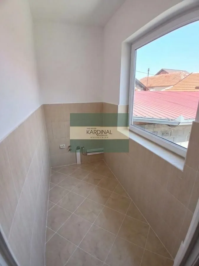 Empty room with tiled floor and walls and a window.