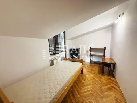 Attic bedroom with wooden flooring and a bed. - image 7