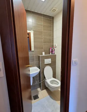 Pogled kroz otvoren vrata na kupatilo sa umivaonikom i šoljom. - image 11