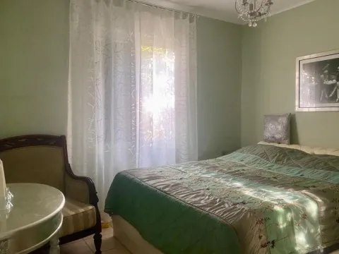 Spavaća soba sa bračnim krevetom, foteljom i prozorom sa zavjesama. - image 9