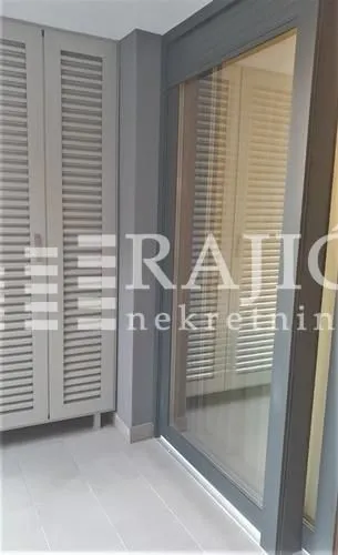 Terasa sa ormanom i staklenim balkonskim vratima.