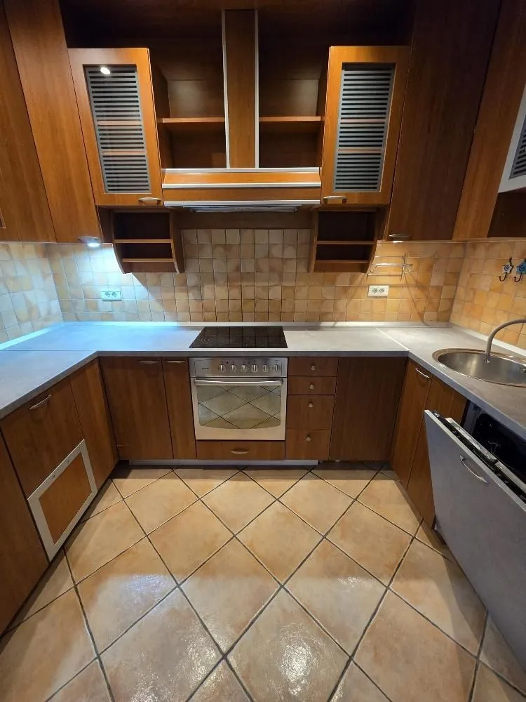 Kitchen equipped with wooden cabinets, built-in oven, and ceramic tiles.