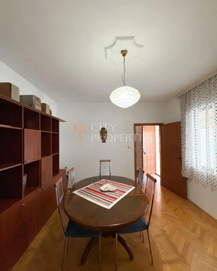 Dining room with a wooden table, chairs, and a large cabinet.