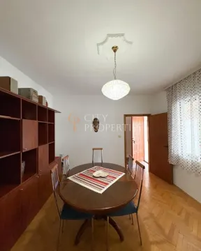 Dining room with a wooden table, chairs, and a large cabinet. - image 8