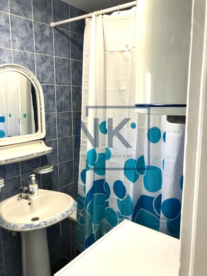 Bathroom with a washbasin, mirror and a shower with a curtain.