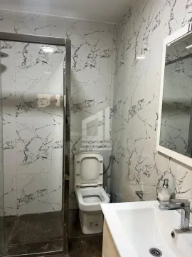 Modern bathroom equipped with a shower cabin, sink, and toilet. - image 5