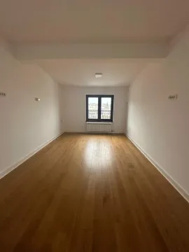 Empty room with wooden flooring and a window at the end. - image 9