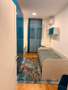 Dječija soba sa krevetom, plavim garderoberom i šarenim tepihom. - image 12