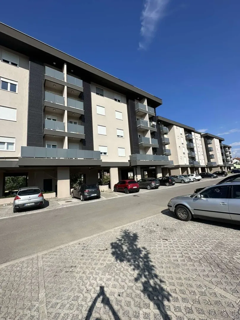 Exterior of a modern residential building with an outdoor parking area.