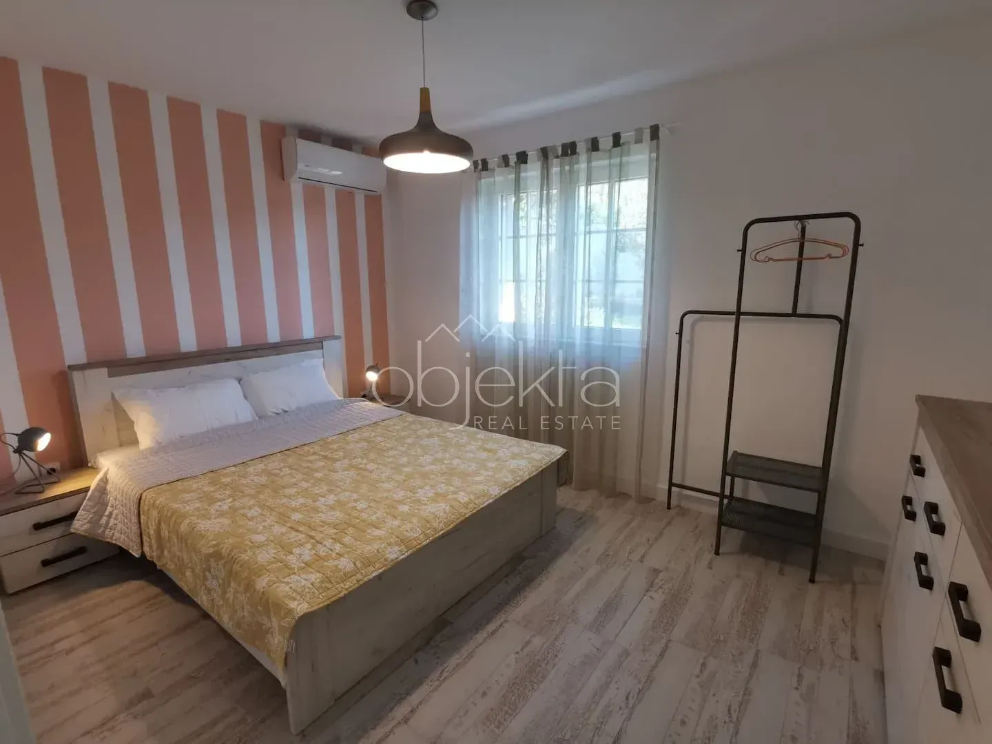 Spacious bedroom with a double bed, wardrobe, and window.