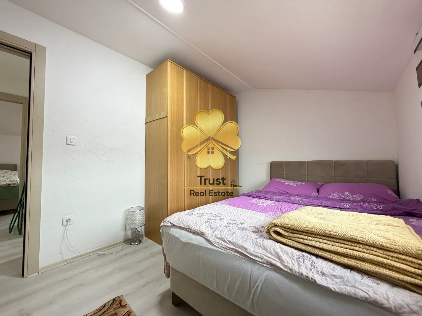 Bedroom with a double bed, wardrobe, and laminate flooring.