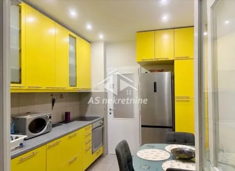 Kitchen with yellow cabinets and a dining table. - image 9