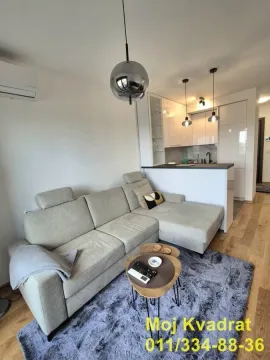 Living room with a sofa and a view of the kitchen. - image 2
