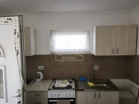 Manja kuhinja sa svetlim drvenim elementima, sudoperom i šporetom. - image 7