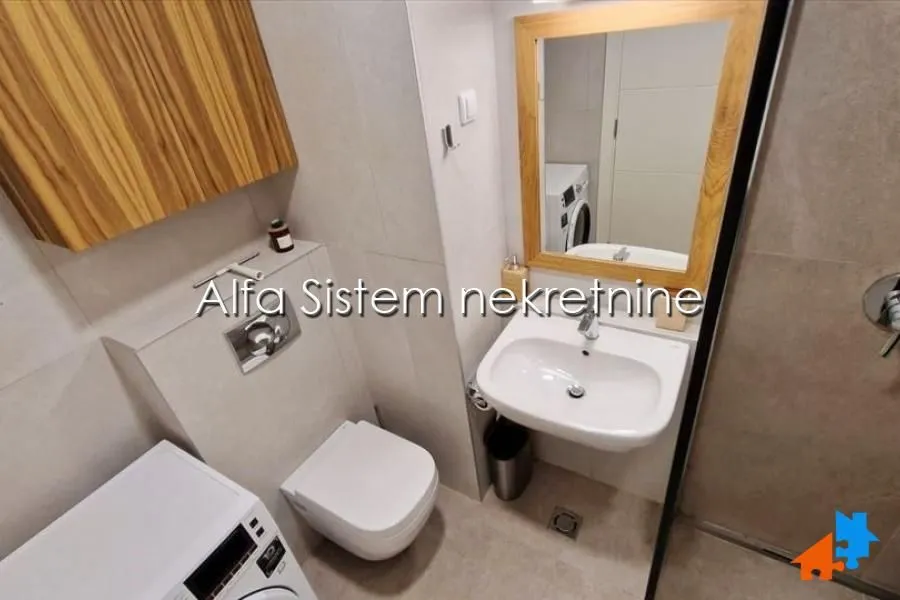 Manje kupatilo sa umivaonikom, ogledalom i toaletom.