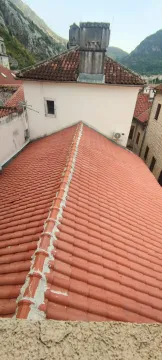 Pogled na krovove okolnih zgrada i planine u pozadini. - image 2
