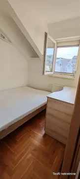 Small bedroom with a bed, dresser, and sloped ceiling. - image 4