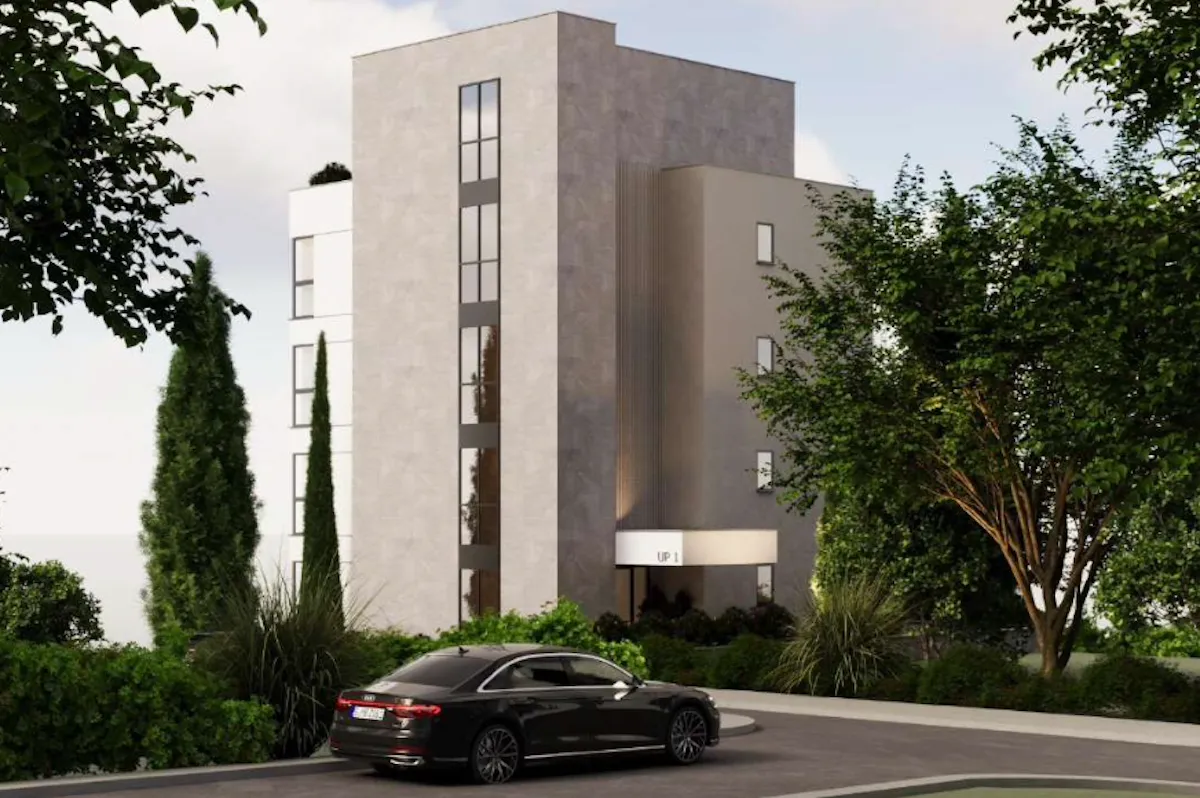 Spoljašnji izgled moderne stambene zgrade sa uređenim dvorištem i prilazom.
