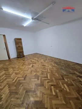 Empty room with wooden parquet flooring and a wood stove. - image 4