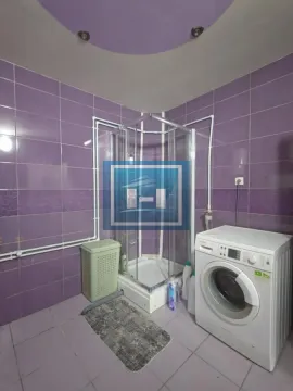 Kupatilo obloženo ljubičastim pločicama sa tuš kabinom i veš mašinom. - image 20