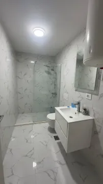 Moderno opremljeno kupatilo sa tuš kabinom i bijelim mermernim pločicama. - image 2