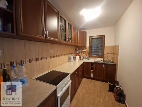 Kuhinja sa drvenim elementima, šporetom i sudoperom pored prozora. - image 4