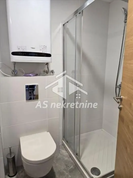 Modernly equipped bathroom with a walk-in shower and water heater.
