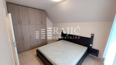 Furnished bedroom with a large double bed and built-in wardrobe under the sloped ceiling. - image 6