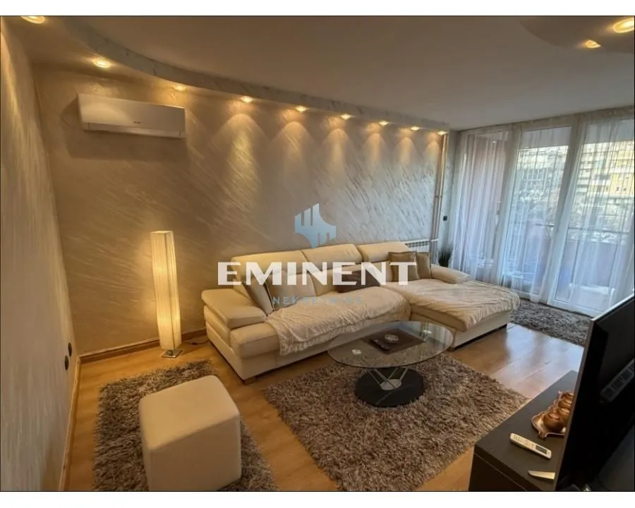 Living room with a sectional sofa, coffee table and balcony access.