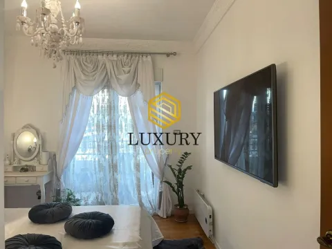Furnished bedroom with a large double bed, television, and balcony doors. - image 10