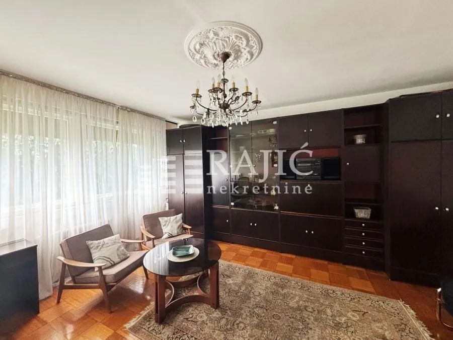 Living room with a sofa set, large wardrobe, and wooden flooring.