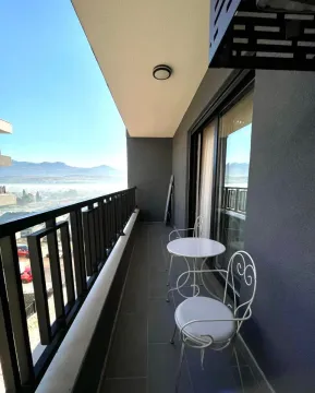 Natkriveni balkon sa garniturom za sjedenje i pogledom na okolinu. - image 10