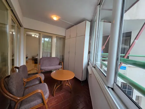 Enclosed balcony with seating furniture and a built-in closet. - image 4