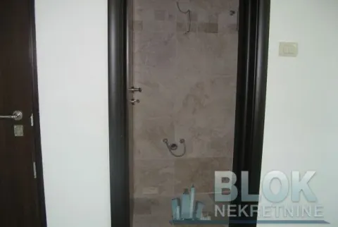 View of a tiled bathroom through an open door. - image 3