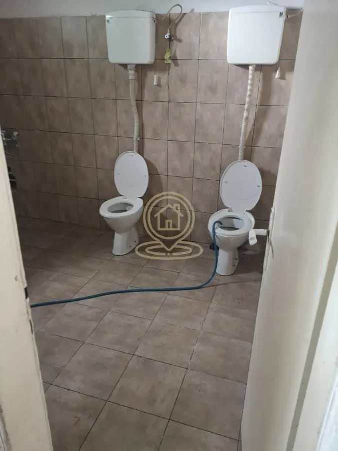A view of a bathroom with two toilet bowls.