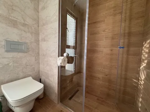 Modernly equipped bathroom with a walk-in shower and toilet. - image 12