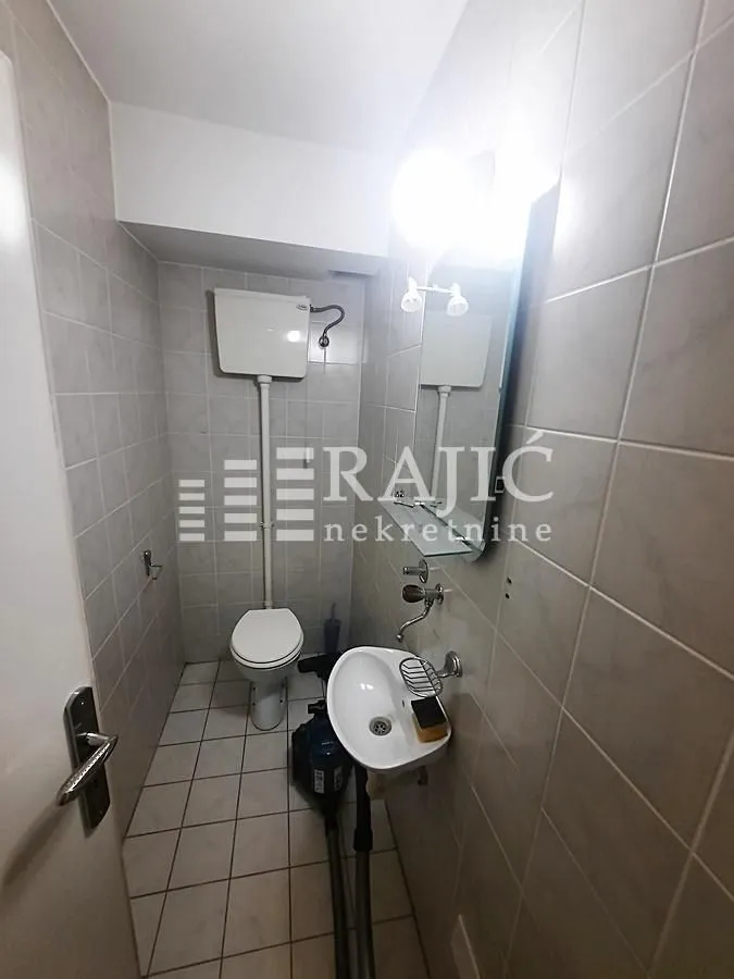 Small bathroom with sanitary ware and wall tiles.
