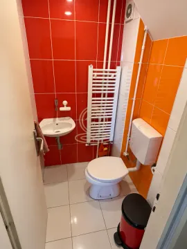 Manje kupatilo sa WC šoljom, umivaonikom i crveno-narandžastim pločicama. - image 10