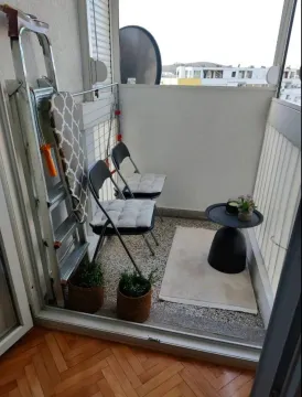 Small enclosed balcony with a table, chairs, and ladder. - image 6