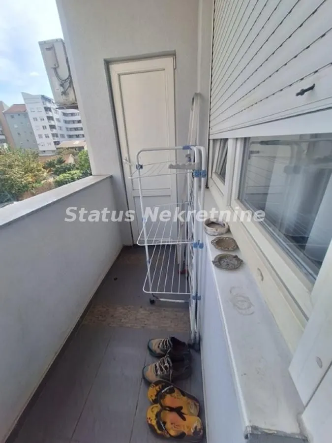 Manji balkon sa sušačem za veš i vratima.